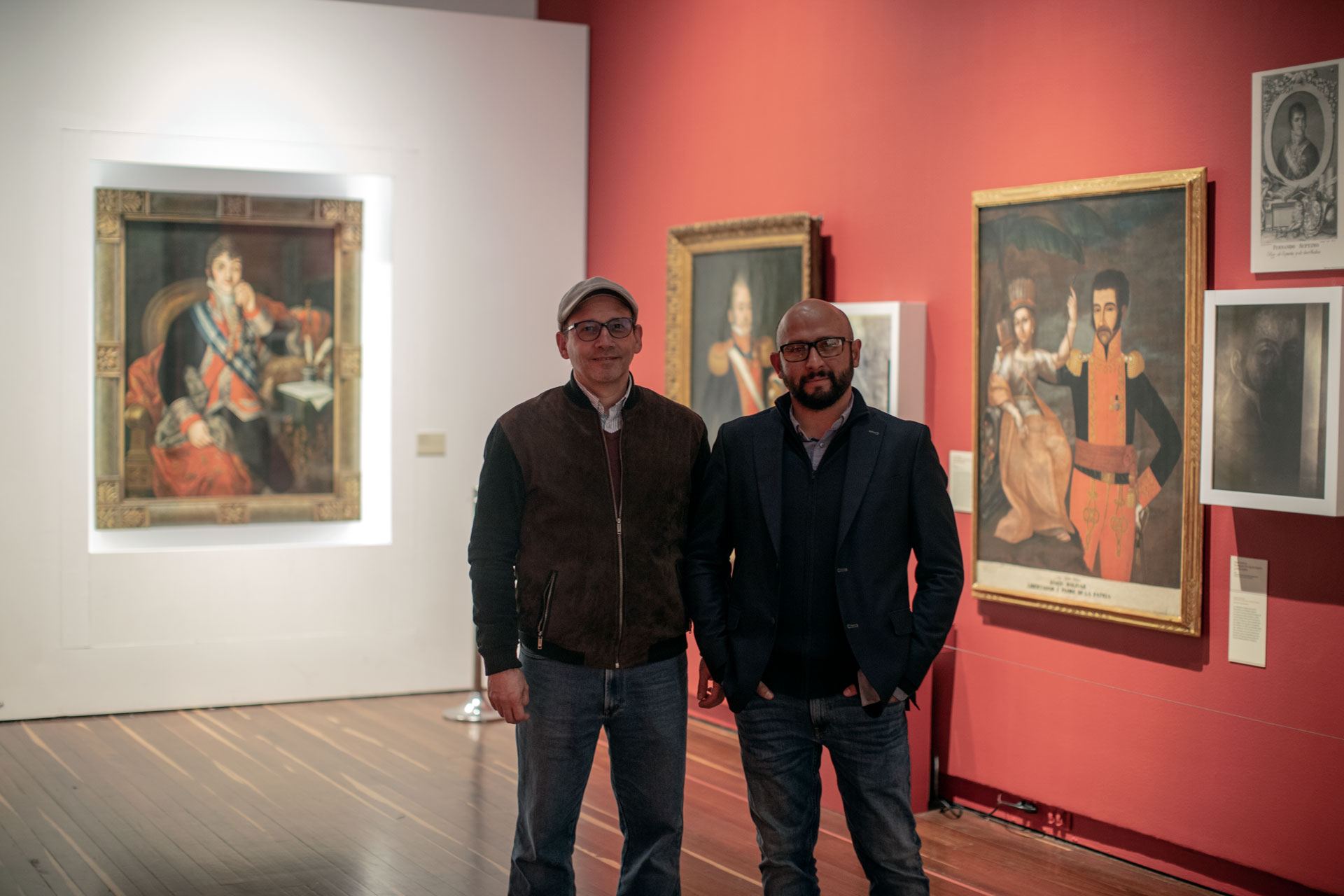 David Cohen y Mario Omar Fernández estudian las pinturas de la exposición del Museo Nacional con luces especiales.